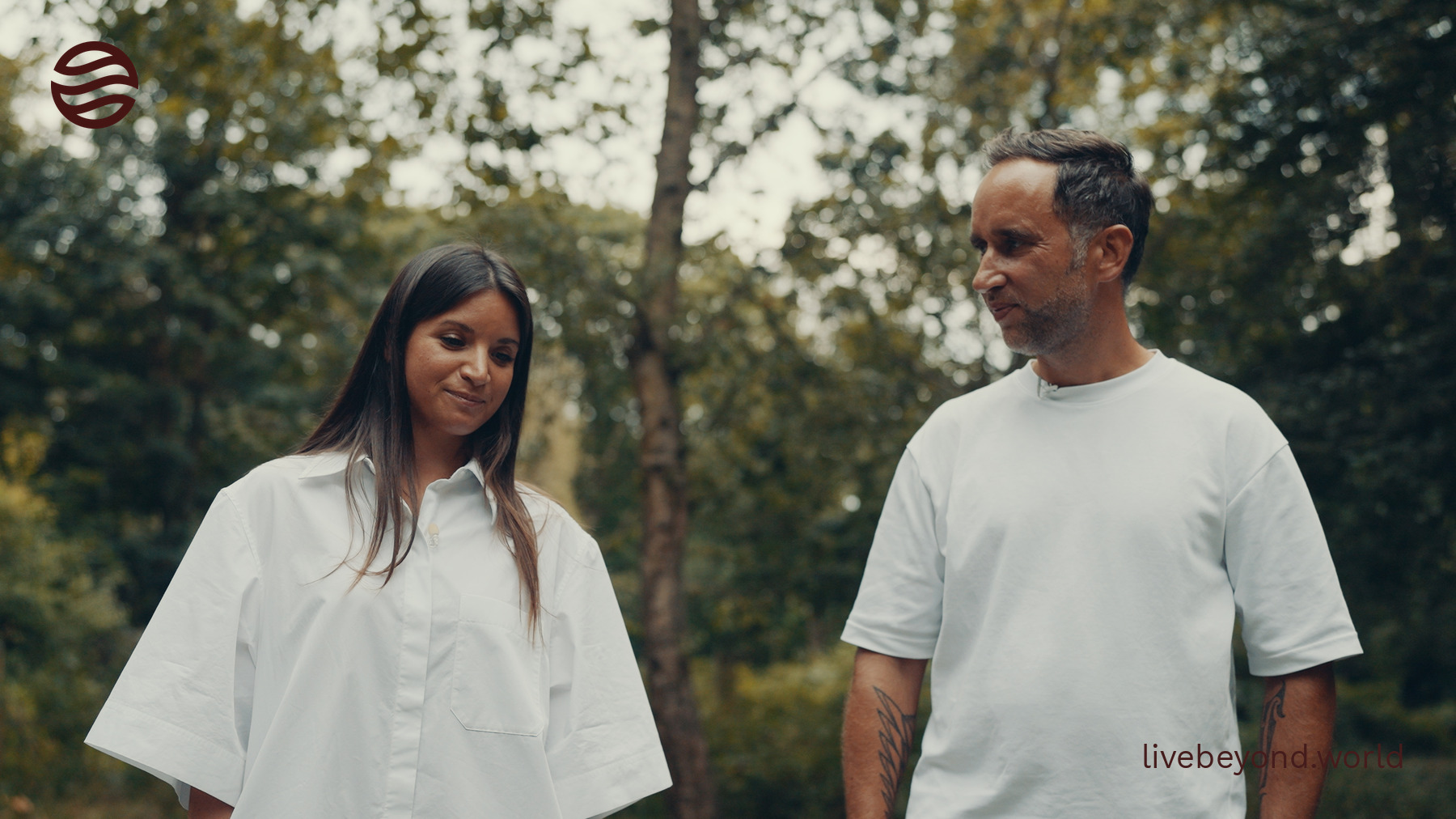 Nikolina Lauc and Marek, both in white, smiling and talking under the trees in a London park.