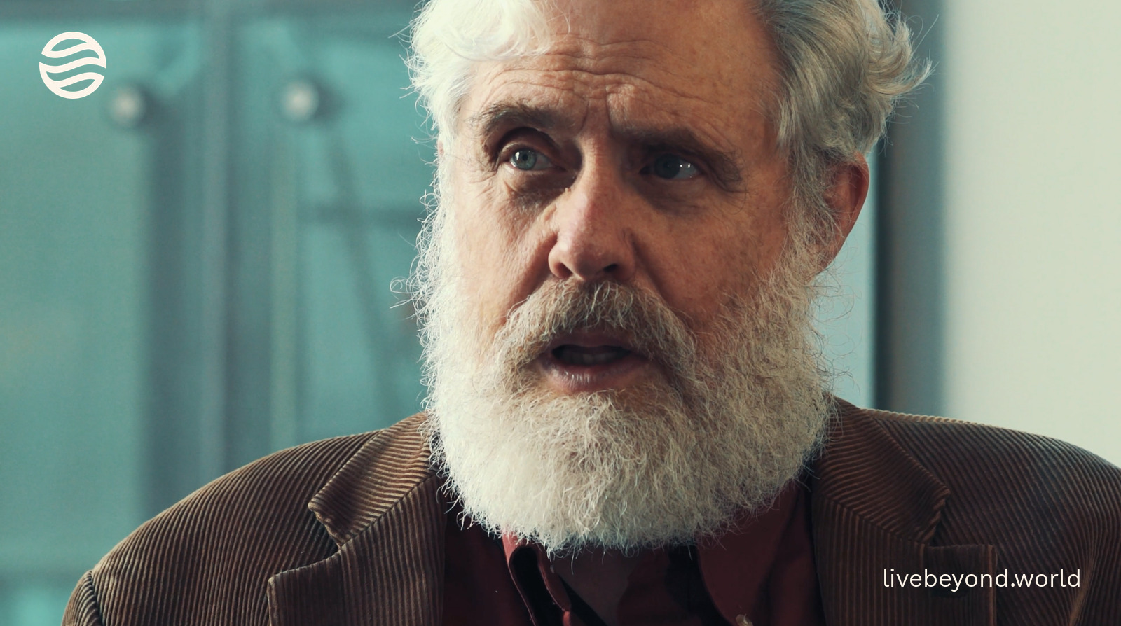 Close-up of George Church listening, with his white beard.