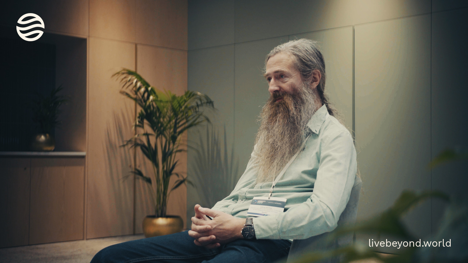 Aubrey de Grey sitting in an interview room, smiling as he talks.