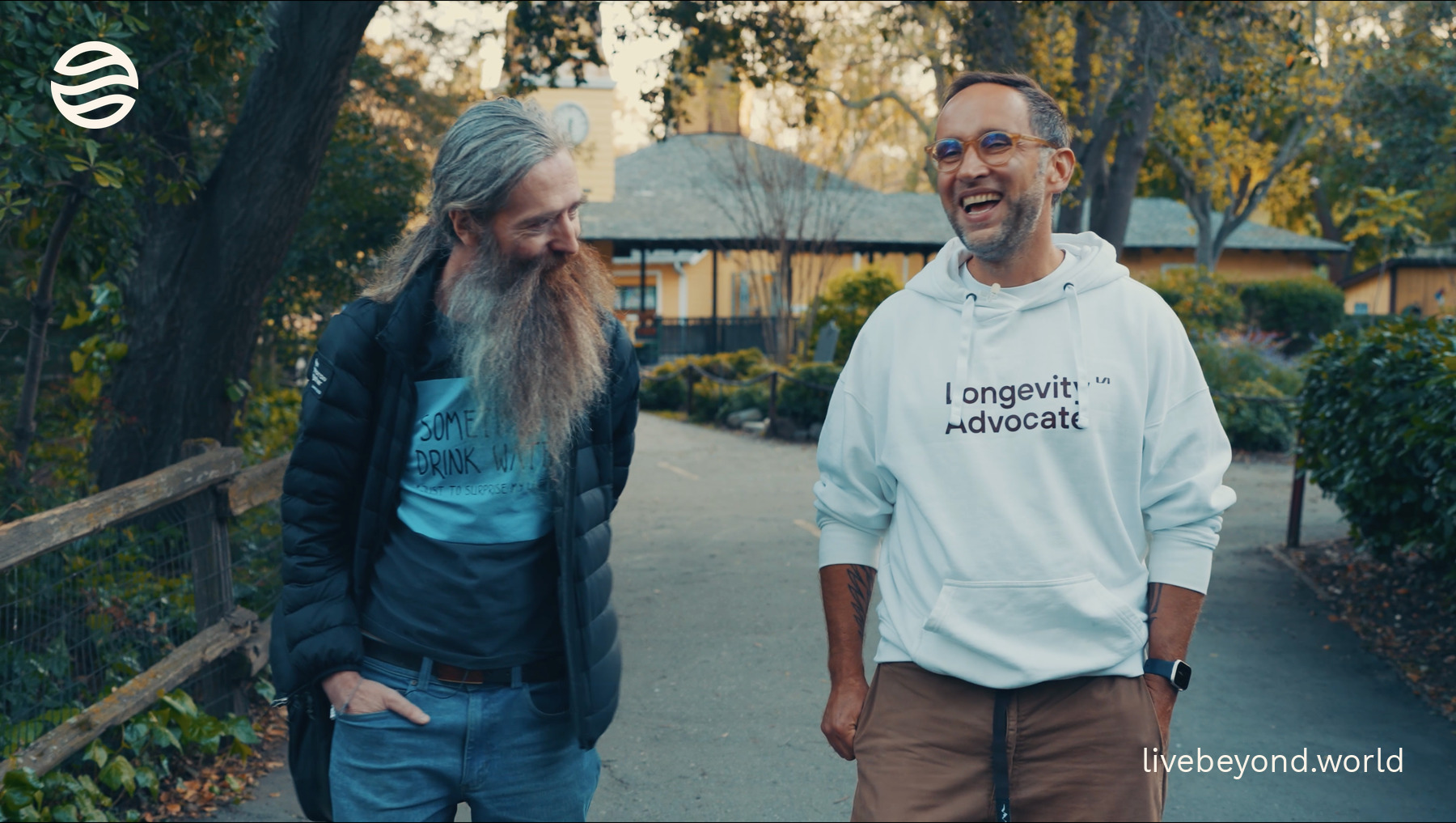 Aubrey de Grey, with his long beard, and Marek laughing together on a garden path in Los Gatos.
