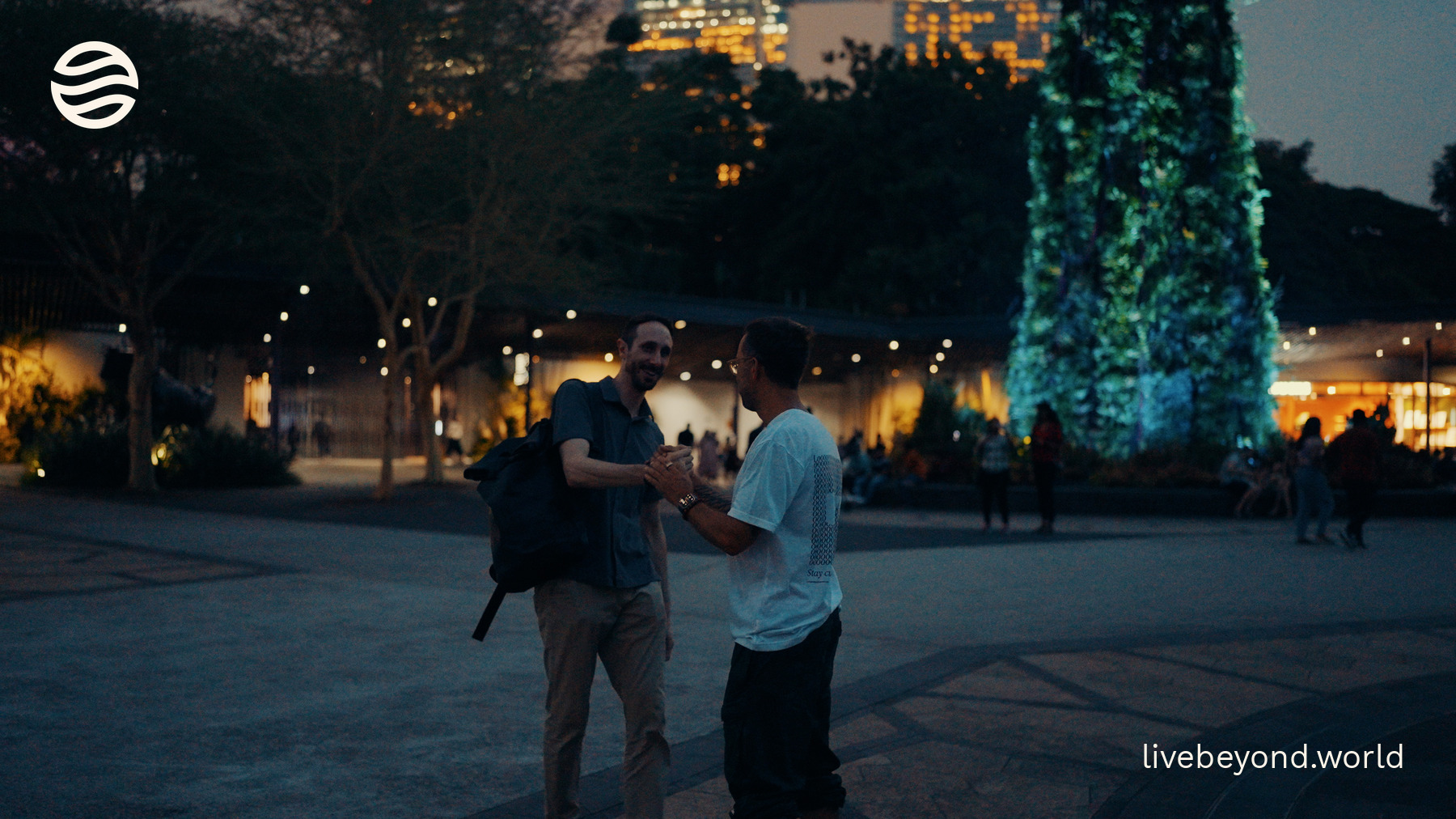 Marek and Vincenzo Sorrentino giving each other a high five at dusk among the lit-up Supertrees in Singapore.