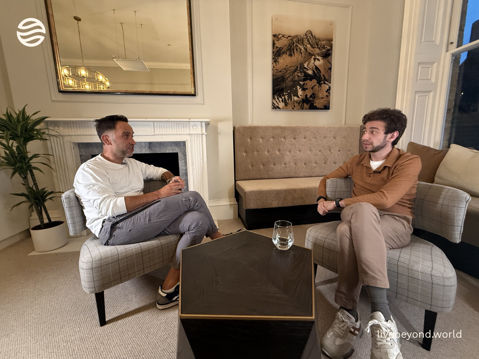 Marek and Boris Djordjevic sitting in armchairs facing each other during an interview in a bright London room.