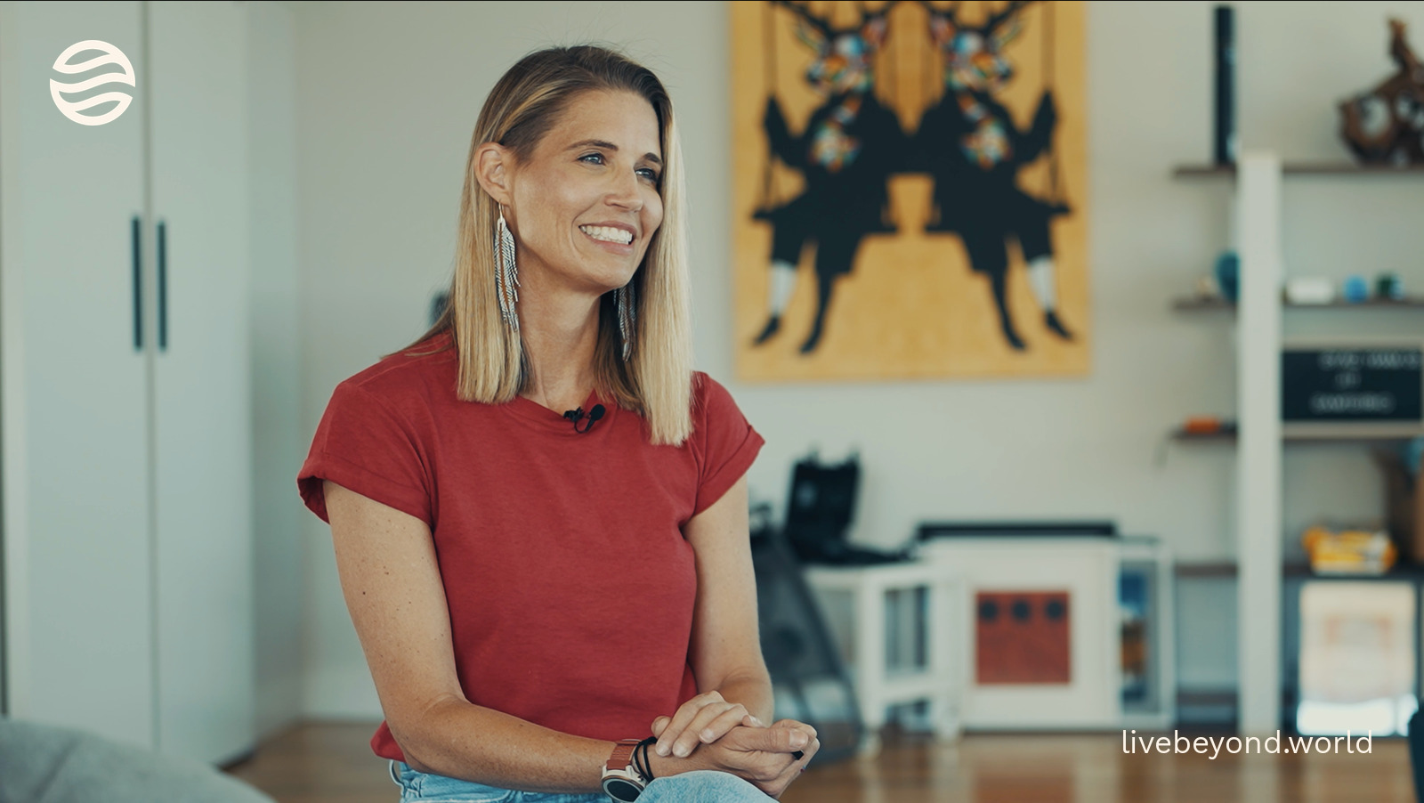 Amy Killen smiling in a red T-shirt in her home.