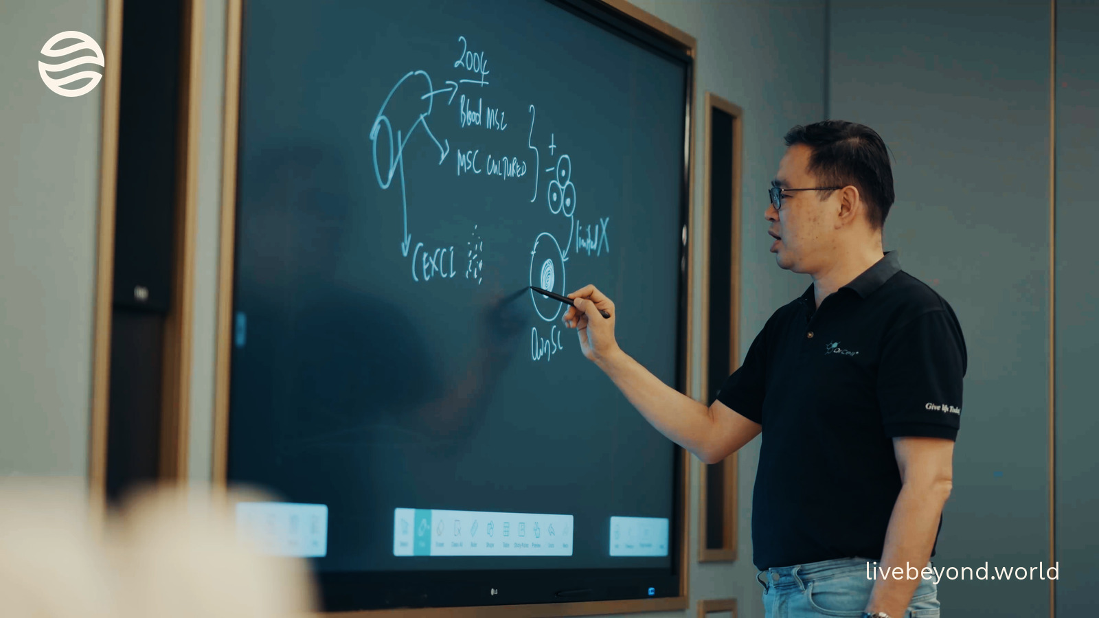 Michael Lim drawing a diagram on a large screen in his clinic.