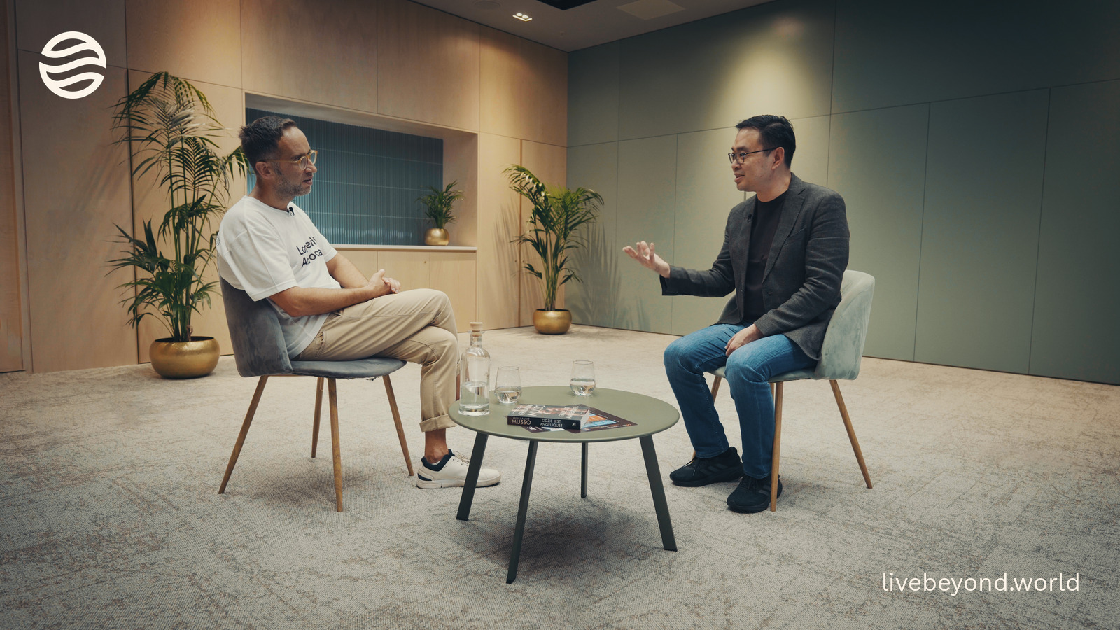 Marek and Michael Lim talking across a small table in an interview room.