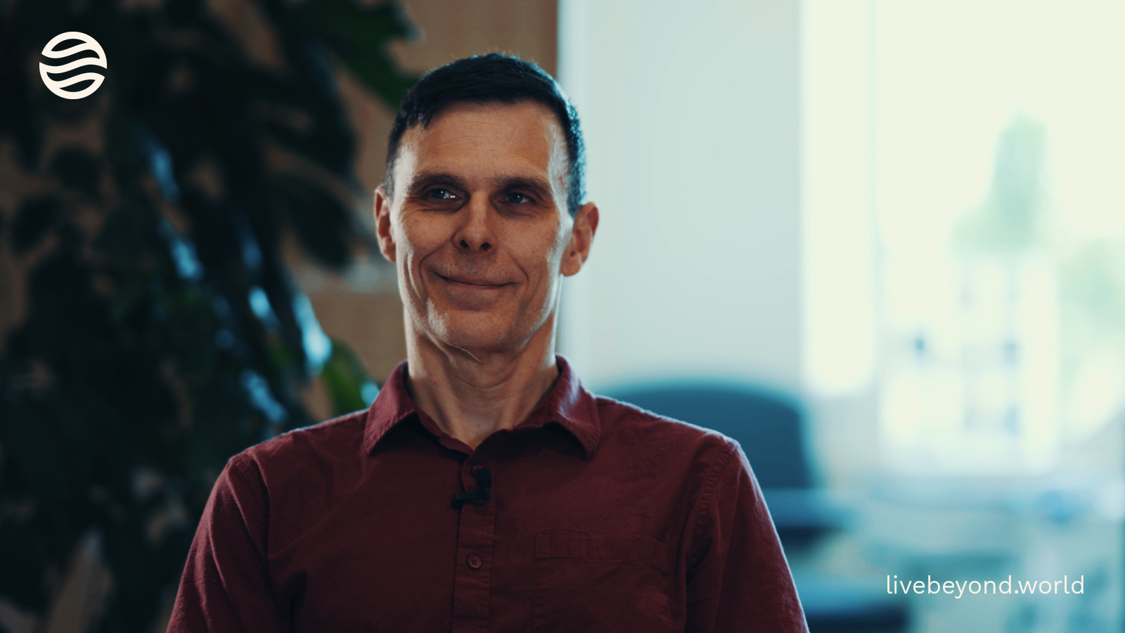 Matt Kaeberlein smiling during an interview, a green plant beside him.
