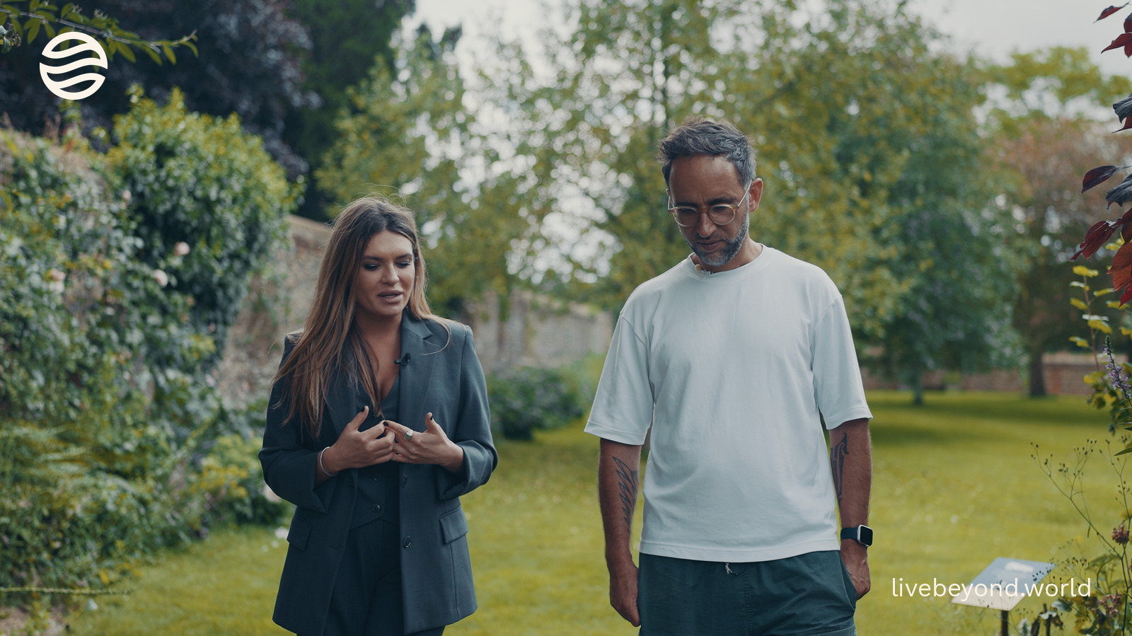 Staša Stanković and Marek walking and talking in a green garden.