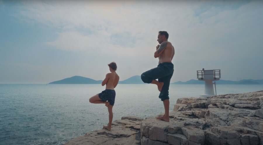 Marek and Alek doing yoga by the sea in Hong Kong