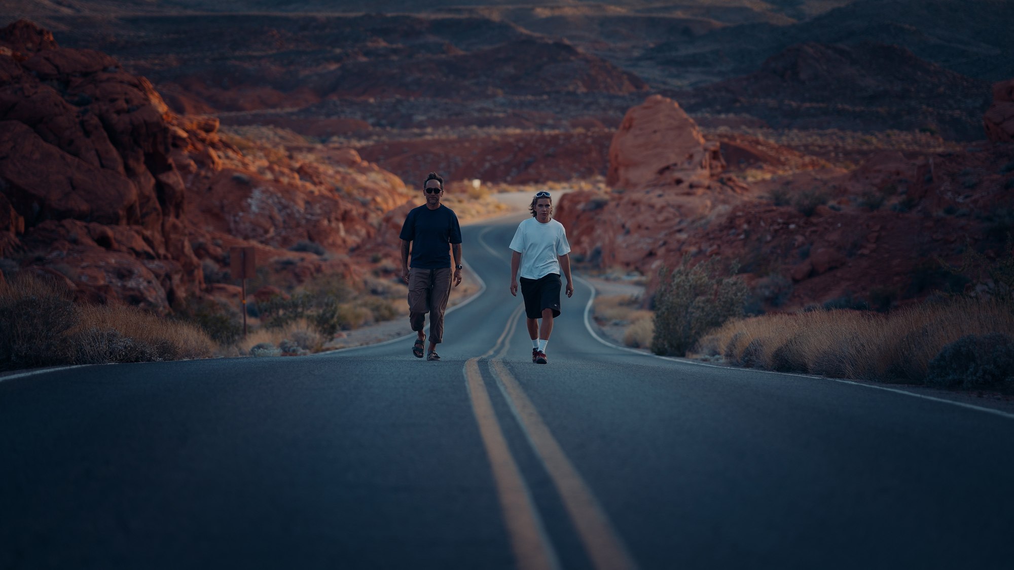 Marek and Aleksander walking a long empty road through the red rocks of Arizona