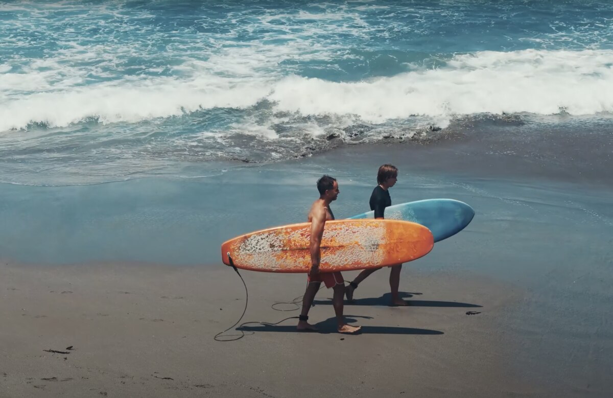 Marek and Aleksander with surfboards on the beach in Bali