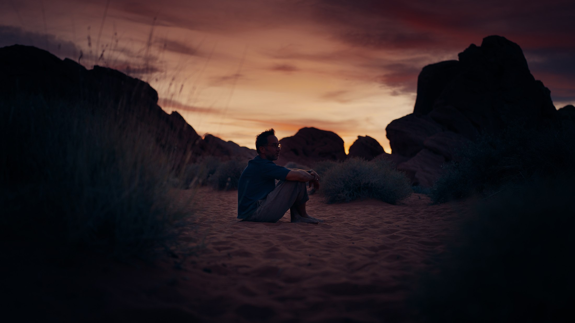 Marek sitting alone among the red rocks at dusk, Arizona