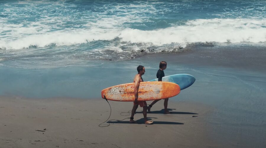 Marek and Alek with surfboards on a beach in Bali