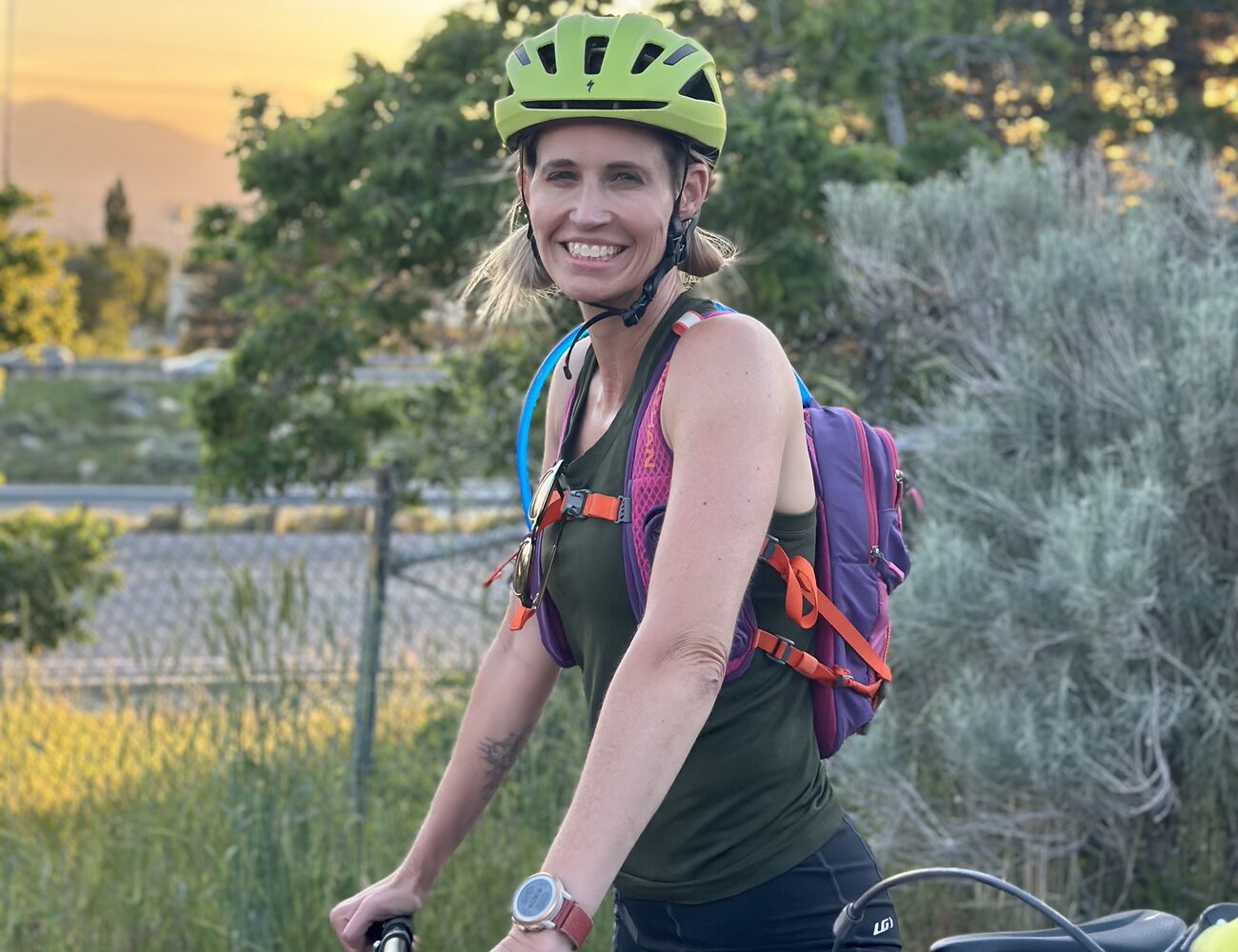 Amy Killen smiling in her cycling helmet at sunset, Utah