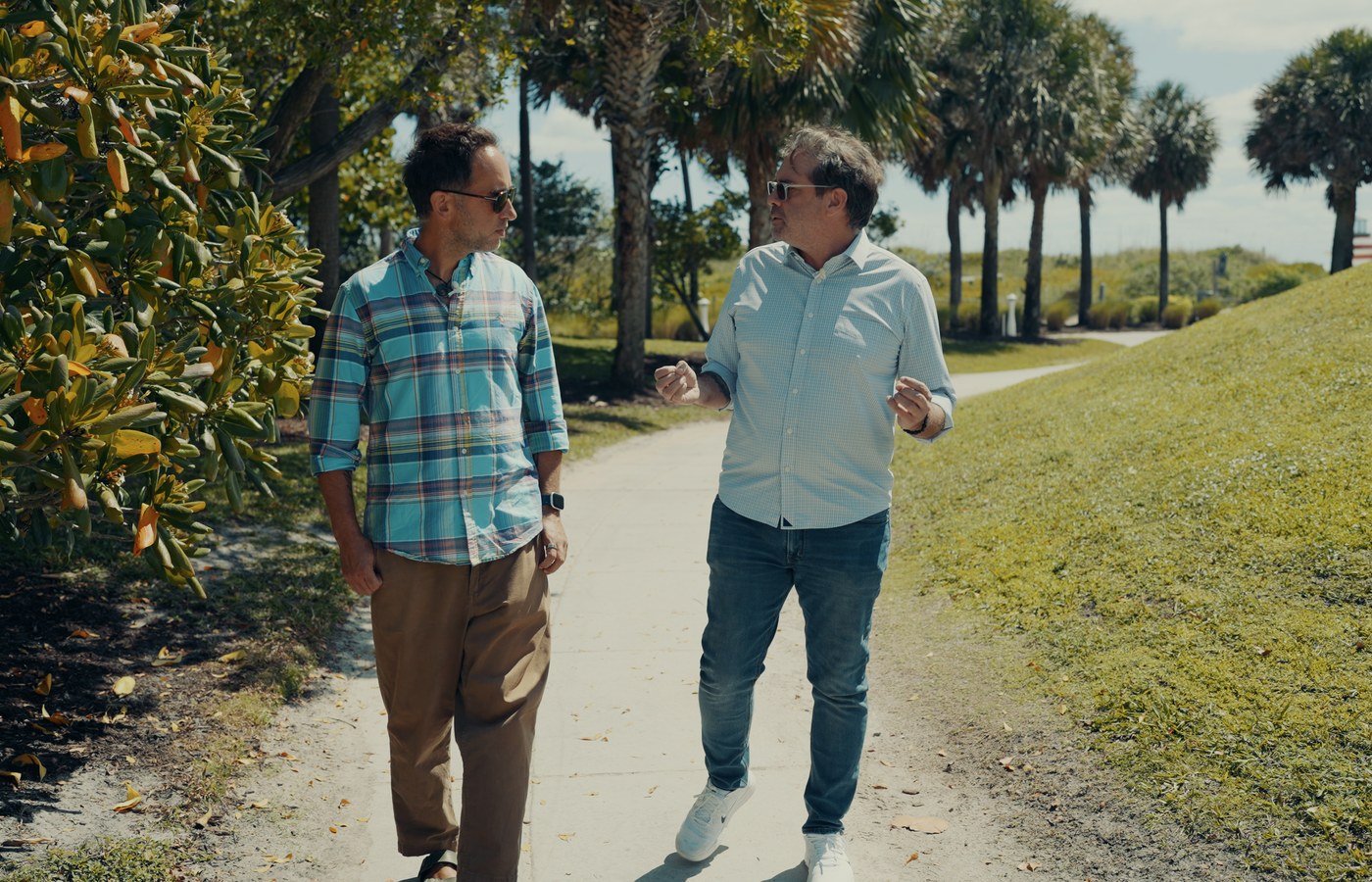 Ian White and Marek walking a palm-lined path in Miami