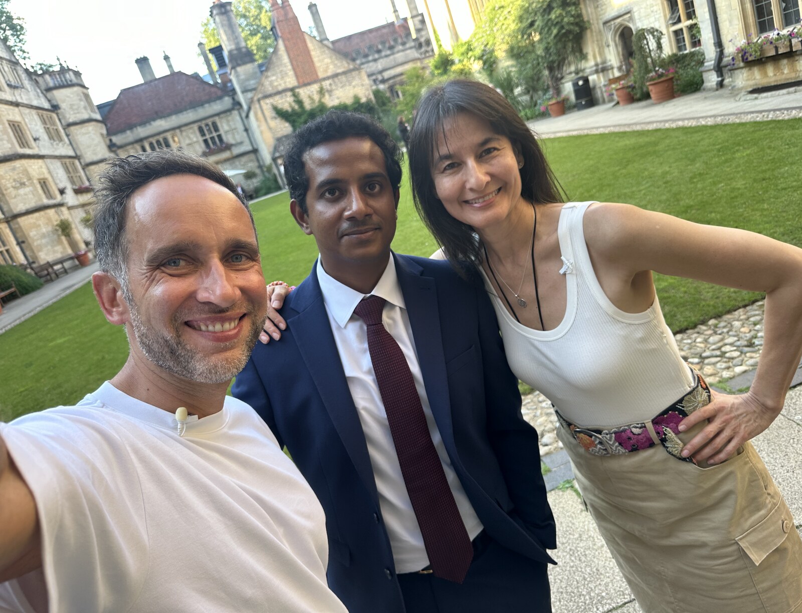 Marek, Sasi Senga and Leslie Kenny smiling together in an Oxford college garden