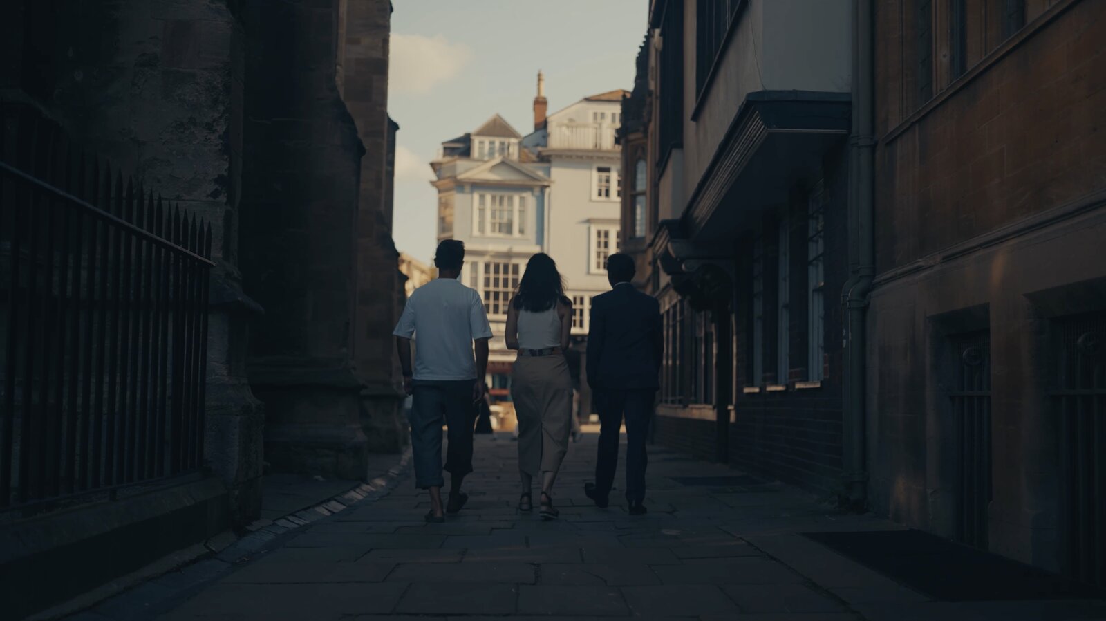 Marek, Sasi Senga and Leslie Kenny walking an old Oxford lane in golden light