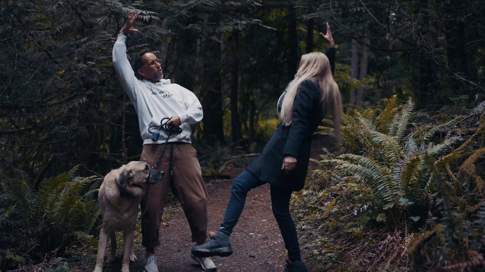 Liz Parrish and Marek sharing a playful moment on a forest trail with the dog