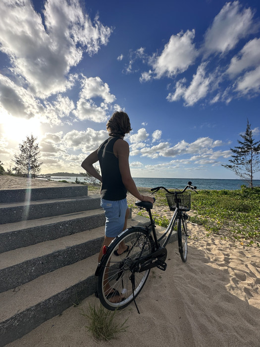 Aleksander Piotrowski with a bicycle beside the sea in Okinawa