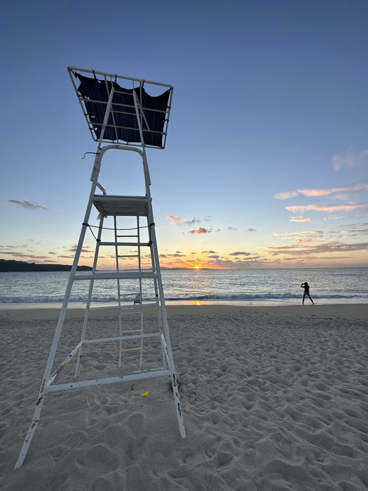 A lifeguard tower on the sand at sunset on a beach in Okinawa