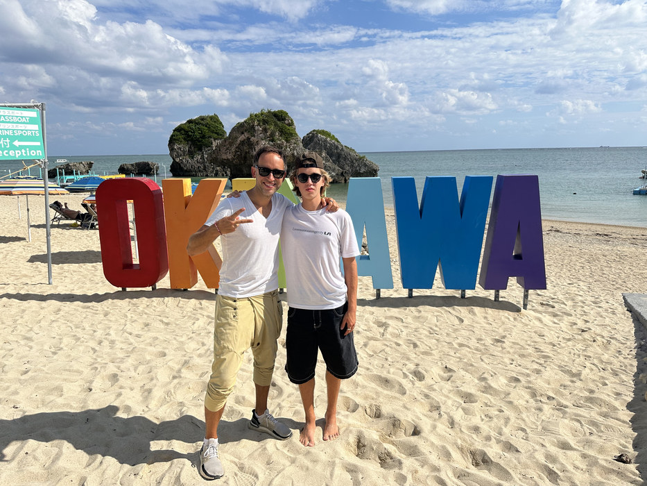 Marek and Aleksander Piotrowski in front of the giant OKINAWA letters on the beach